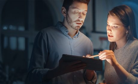 Two people looking at the screen of a tablet