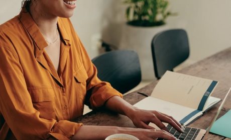 Woman smiling while working on her laptop