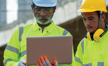 Two people looking at a tablet on a construction site