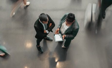 Two people talking in a busy office setting